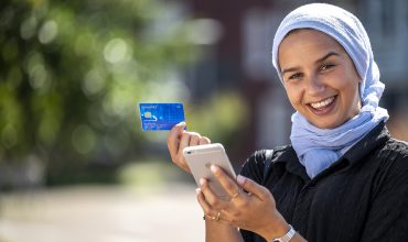 Jonge moslima met betaalpas en mobiel